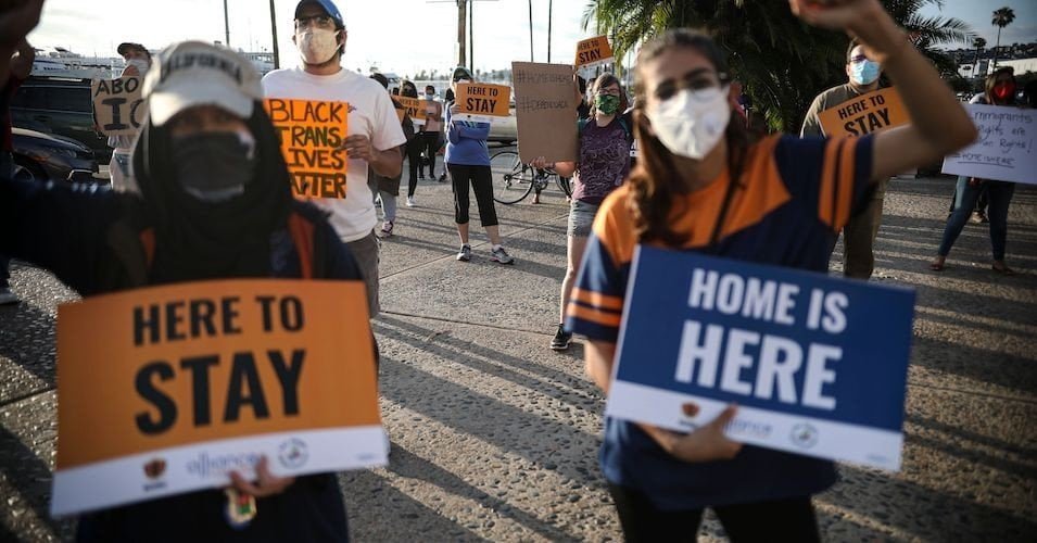 People hold signs during a rally in support of the Supreme Court's ruling in favor of the Deferred Action for Childhood Arrivals (DACA) program, in San Diego, California on June 18, 2020.